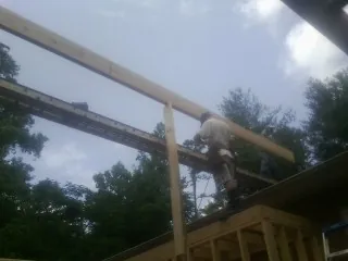 Carpenter setting a ridge beam over a new addition frame — Ice Dam Removal by Roofing Brothers in Rexford