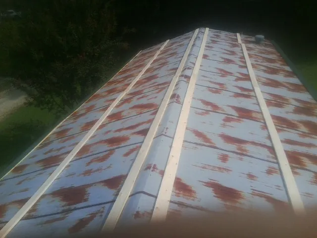 Rusted metal roof panels with new wood purlins before replacement — Storm Damage Roof Repair in Rexford by Roofing Brothers