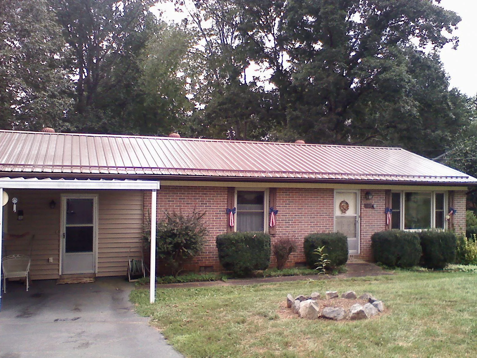 Bronze metal roof and carport on a brick ranch home — Roof Repair work by our crew in Rexford