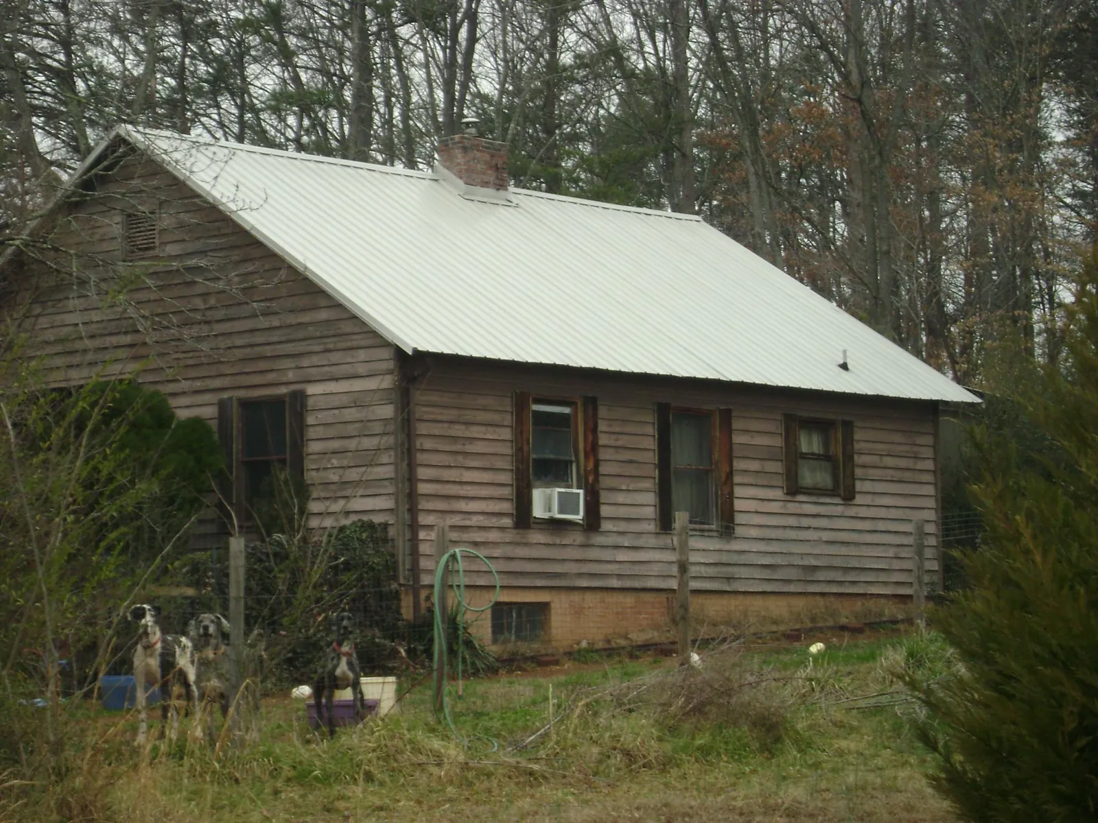 White metal roof on an old wood sided farmhouse, from a Metal Roof Installation job in Rexford